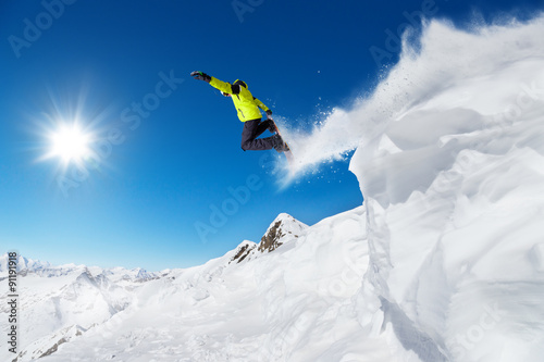 Jumping snowboarder at jump