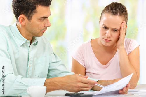 Man and woman worried and calculating their expenses