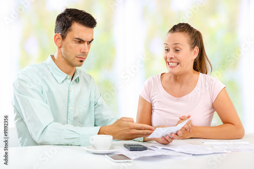Problems in home economy. Young couple figuring out who is to blame for large bills.