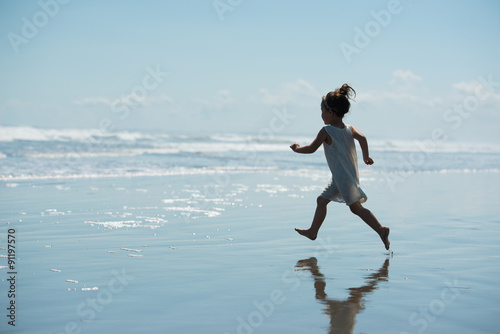 波打ち際を走る少女のシルエット