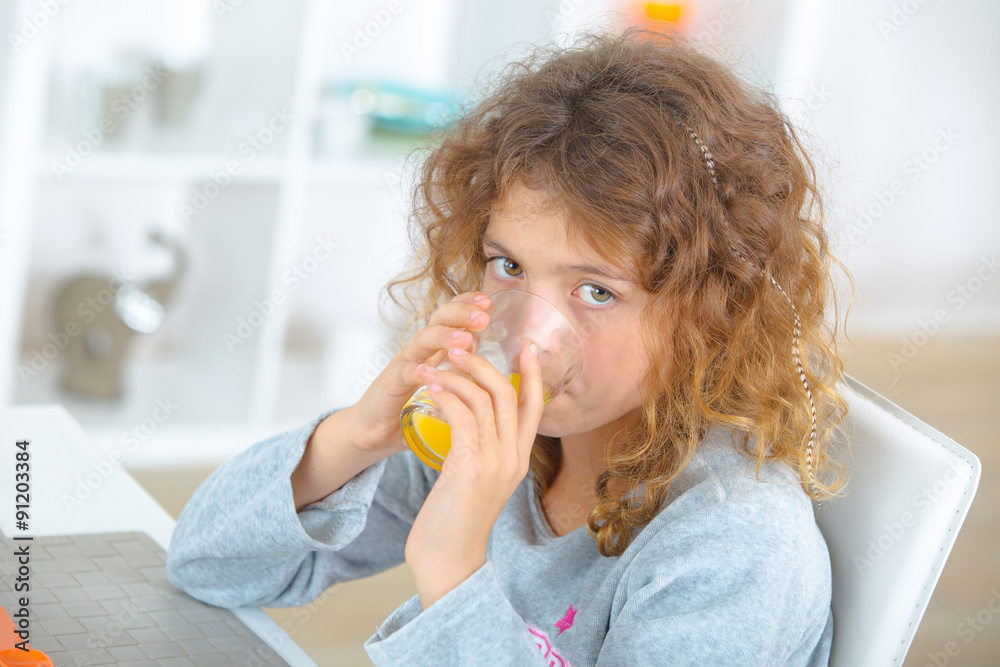 Young girl drinking orange juice