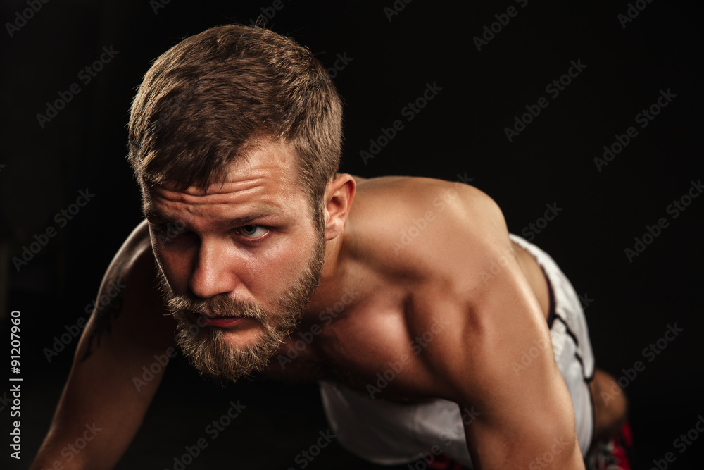 Athletic bearded boxer with gloves on a dark background Athletic bearded boxer with gloves on a dark background