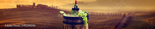Red wine bottle and wine glass on wodden barrel. Beautiful Tusca