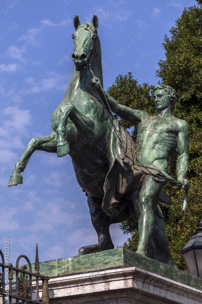 Fototapeta premium Statue of a young man holding a hourse