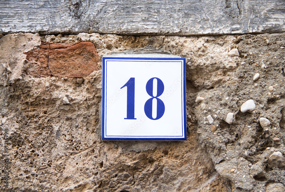 Number eighteen on the grey stone wall Number eighteen on the grey stone wall