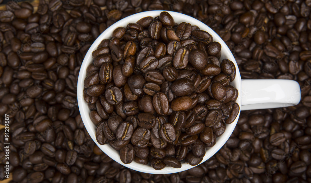 Fototapeta premium Cup of Coffee Beans Surrounded by Coffee Beans High Angle View