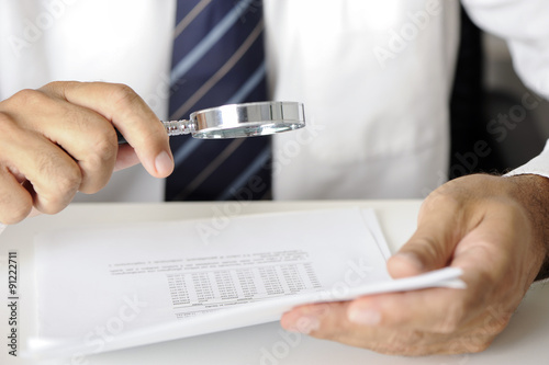 Canvastavla Businessman with magnifying glass reading documents