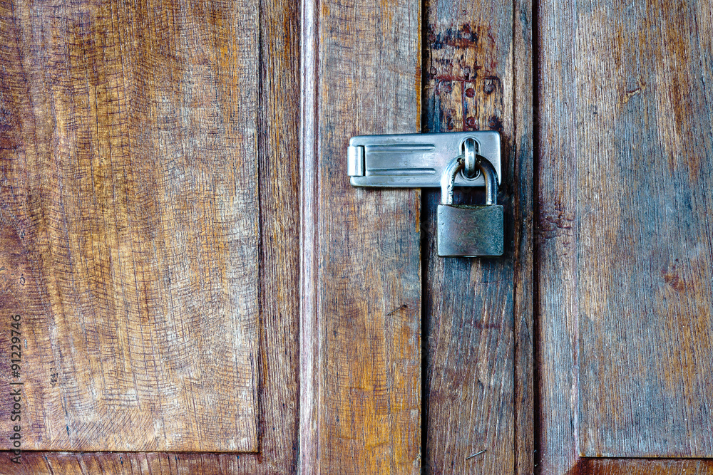 Old padlock on a wooden door Old padlock on a wooden door