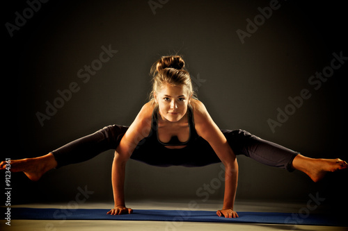Young woman doing yoga exercise on mat #91234361