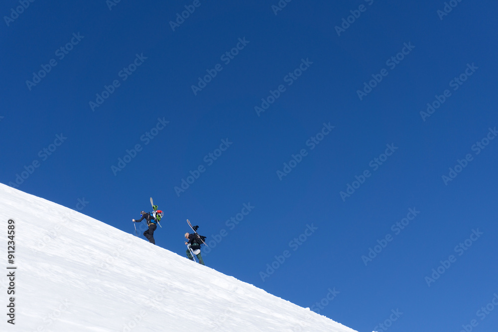 Snowboarders walking uphill for freeride
