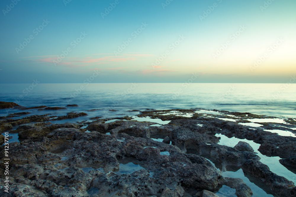 Sunset over the rocky shore of the Mediterranean Sea. Toned