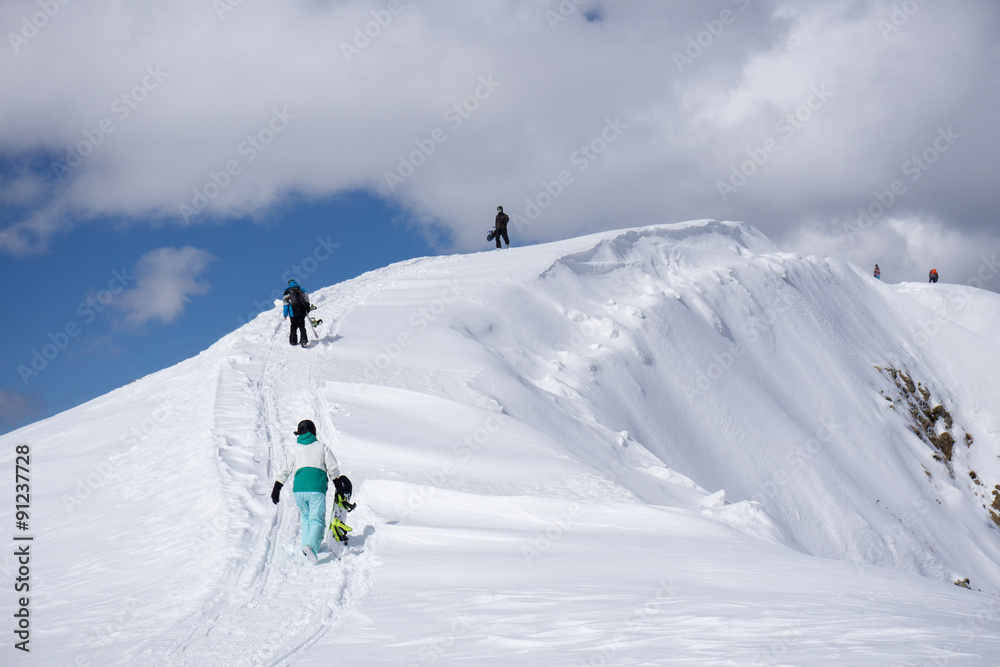 Snowboarders walking uphill for freeride