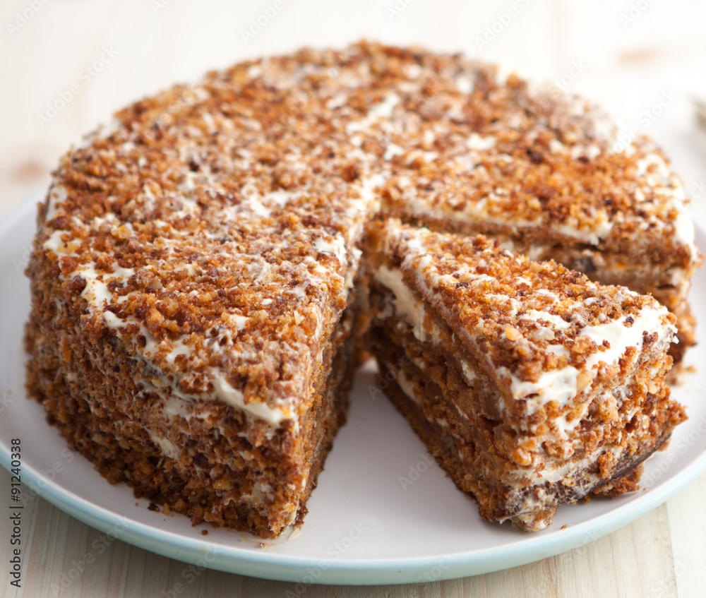 Homemade carrot and walnut cake with cut piece on a wooden table Homemade carrot and walnut cake with cut piece on a wooden table