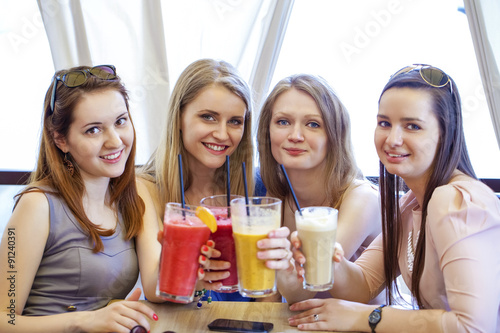 Four young girls have a rest in a summer cafe