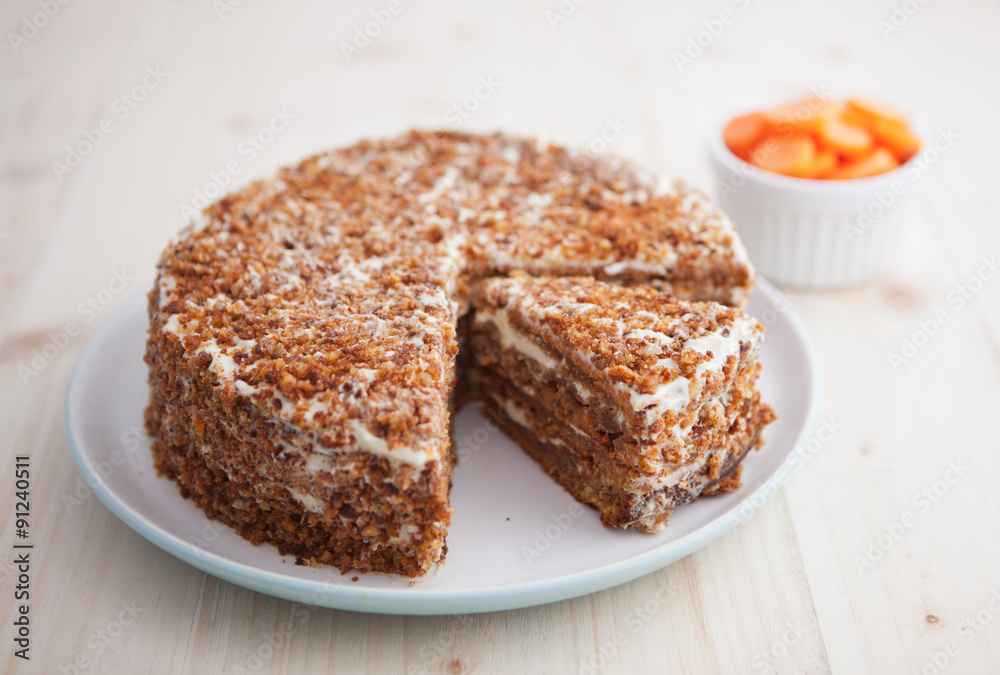 Homemade carrot and walnut cake with cut piece on a wooden table Homemade carrot and walnut cake with cut piece on a wooden table