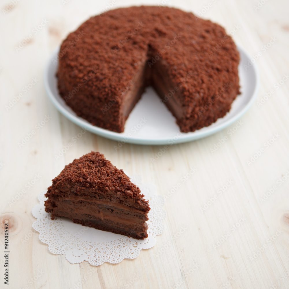 Homemade chocolate blackout cake with a cut piece on a light wooden table Homemade chocolate blackout cake with a cut piece on a light wooden table