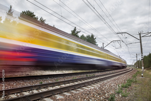 passenger train on railroad tracks in speed motion