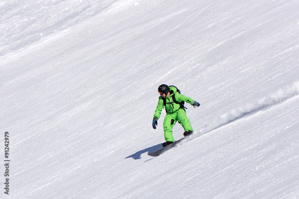 Snowboarder going down the slope at ski resort.
