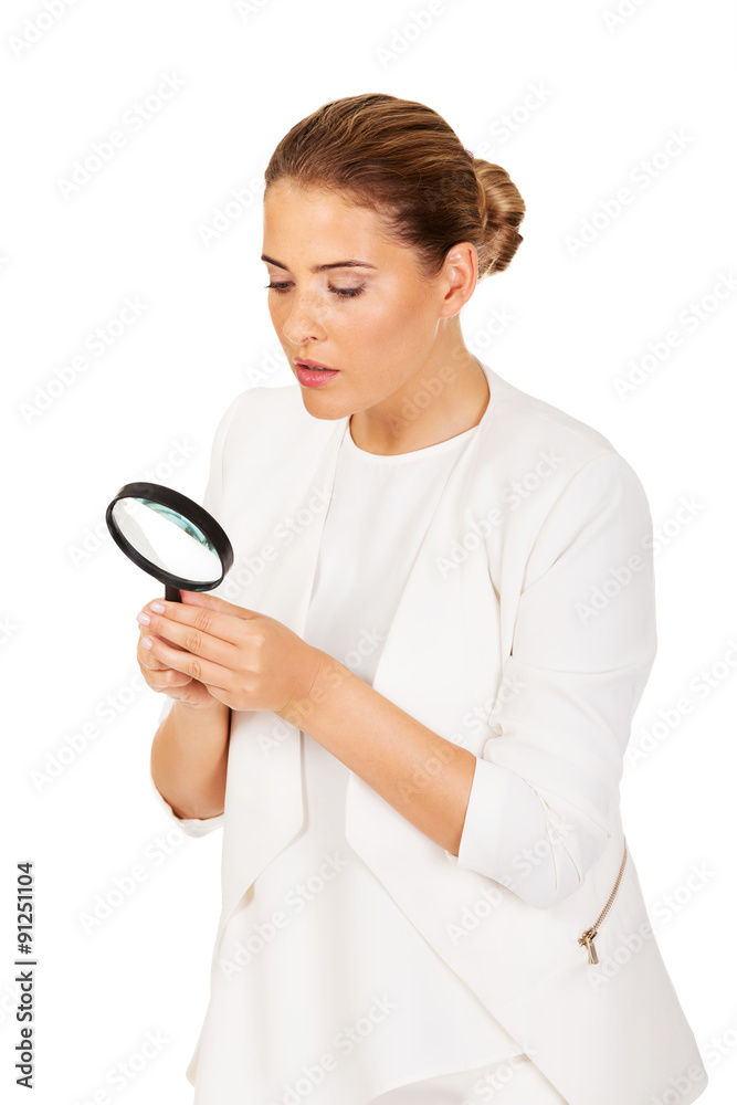 Young attractive businesswoman looking into a magnifying glass Young attractive businesswoman looking into a magnifying glass