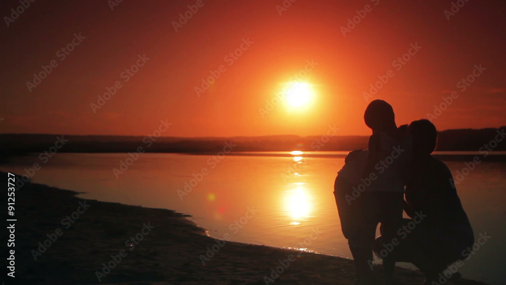 two boys ran to a happy mother and held her on the beach at two boys ran to a happy mother and held her on the beach at