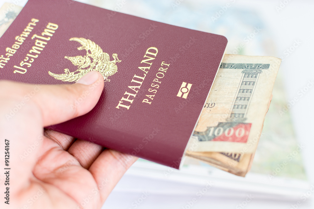 Thailand passport for tourism with Nepali notes hold in hand Thailand passport for tourism with Nepali notes hold in hand