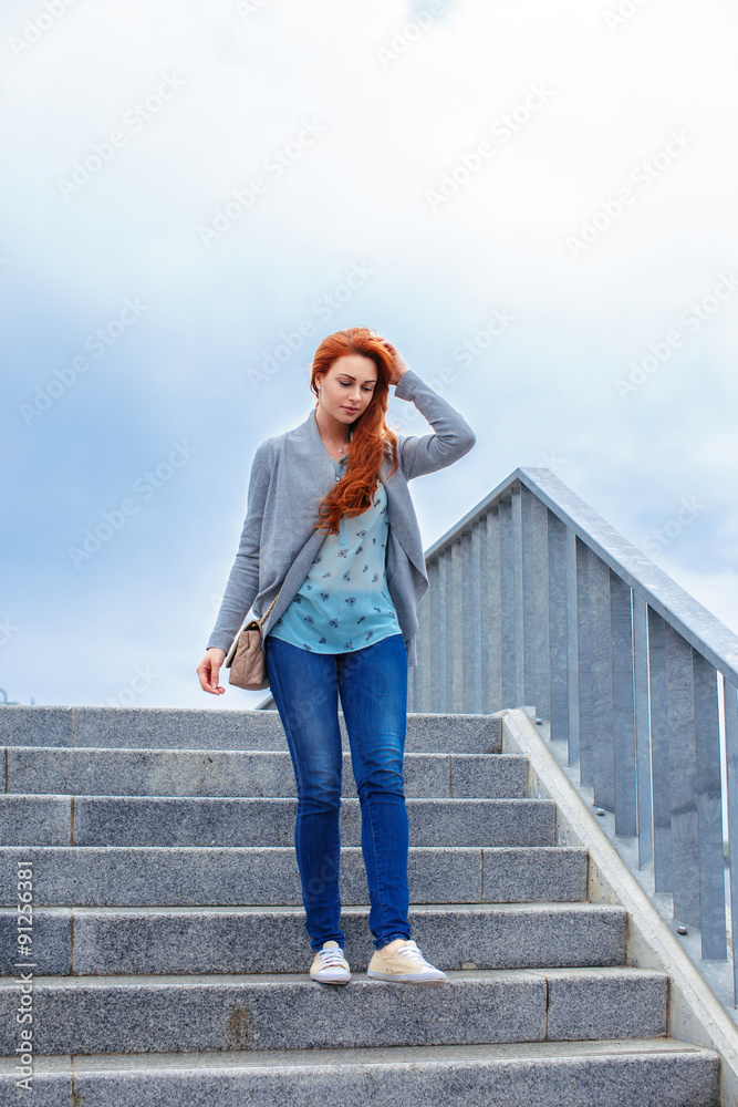 Redhead casual girl walking down stairs. Redhead casual girl walking down stairs.