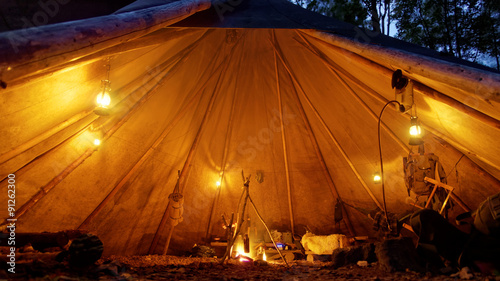 cozy tipi with oil lamps and camp fire