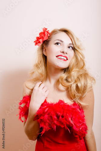 Surprised girl in red dress with flower barrette and boa