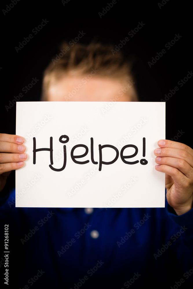 Child holding sign with Norwegian word Hjelp - Help Child holding sign with Norwegian word Hjelp - Help
