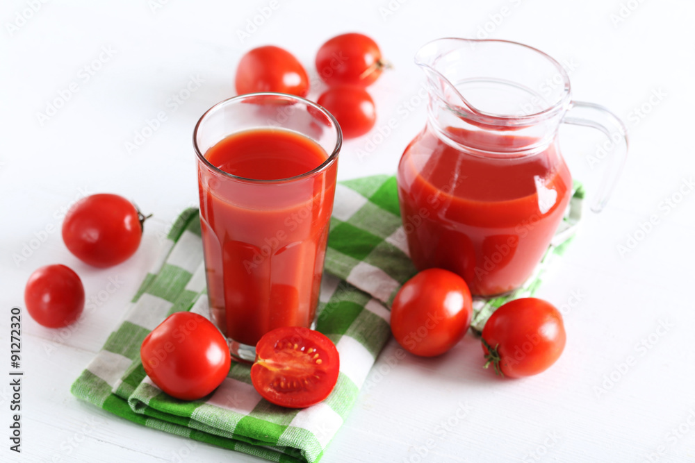 Fresh red tomatoes in basket and tomato juice in glass and jug o Fresh red tomatoes in basket and tomato juice in glass and jug o