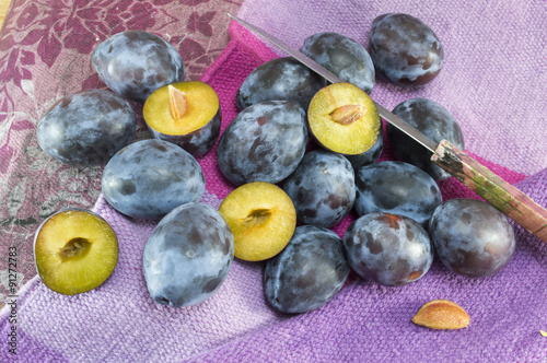 Bunch of fresh plums on a purple background