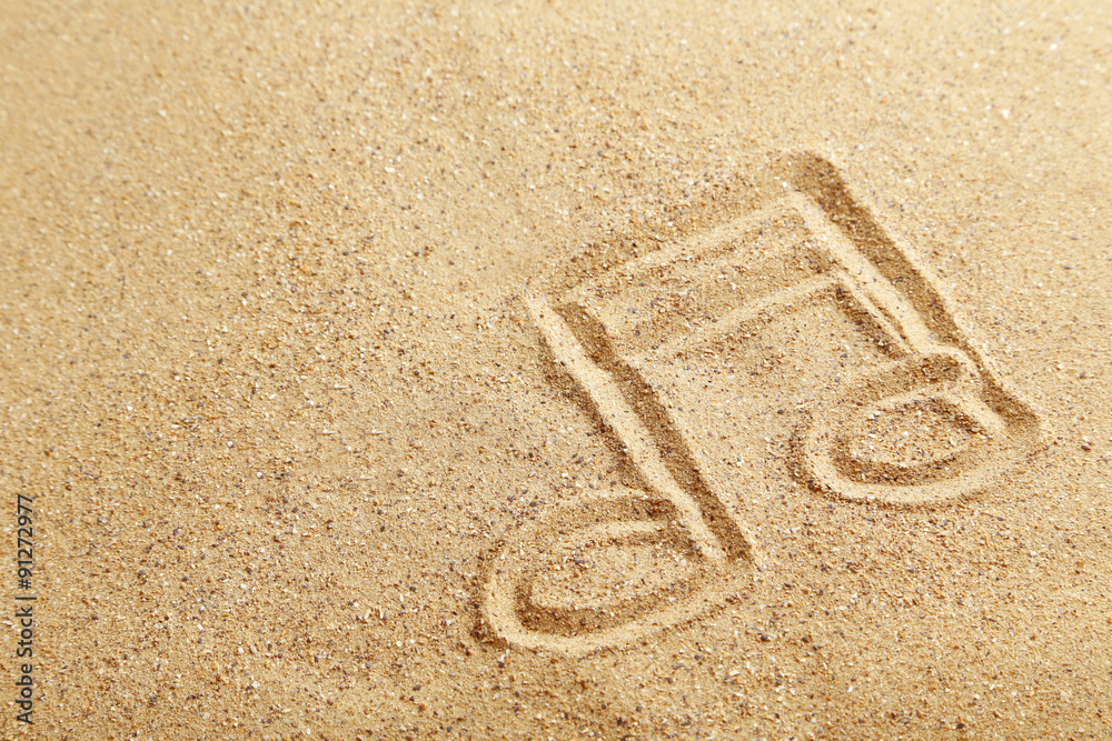 Music note drawn on a beach sand
