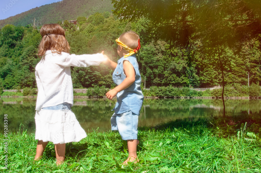 Fototapeta premium children holding hands look the lake