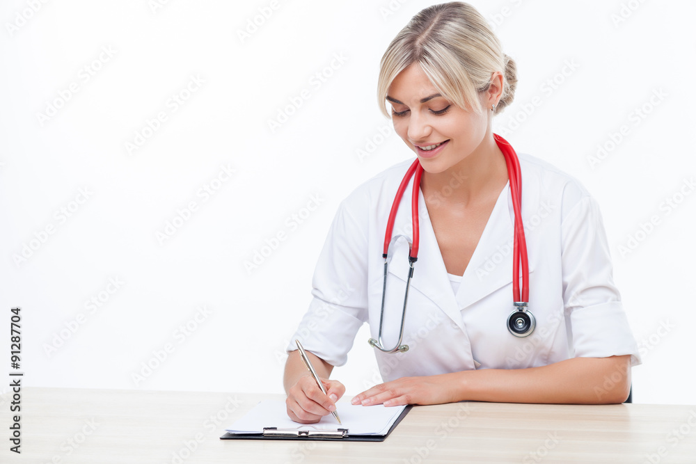Beautiful blond female physician is working at the table Beautiful blond female physician is working at the table