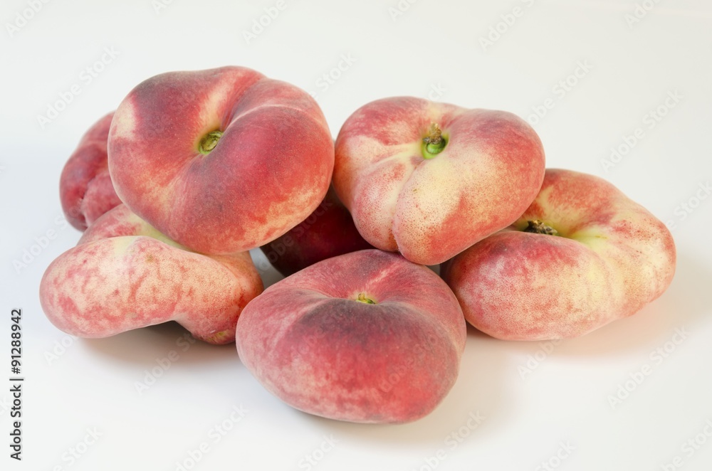 Six whole, medium-size, ripe, juicy saturn peaches shaped like a donut with a sunken middle, white skin with red blush isolated on background. An oddly doughnut like flat round peach yet tasty. Six whole, medium-size, ripe, juicy saturn peaches shaped like a donut with a sunken middle, white skin with red blush isolated on background. An oddly doughnut like flat round peach yet tasty.