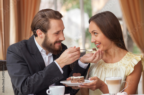 Cheerful young loving couple is dating in restaurant