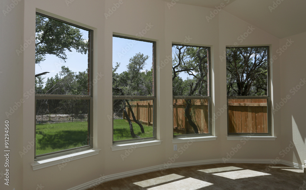 Fototapeta premium Windows of new modern house with view on green backyard and new fence 