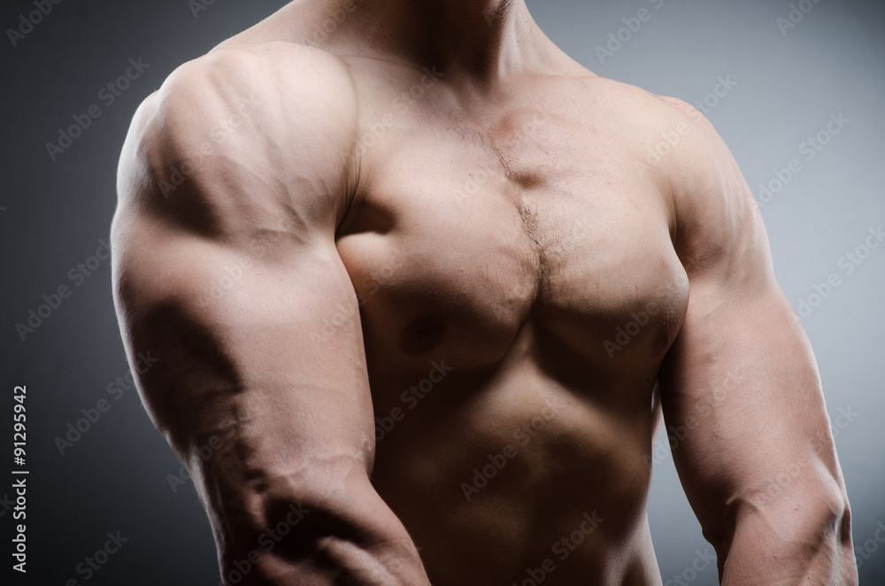 Muscular man posing in dark studio Muscular man posing in dark studio
