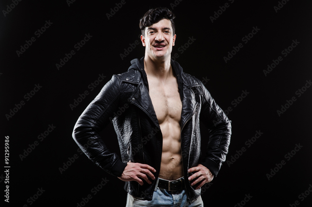 Muscular man posing in dark studio