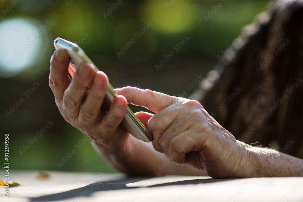 finger of aged hand touching a mobile phone finger of aged hand touching a mobile phone