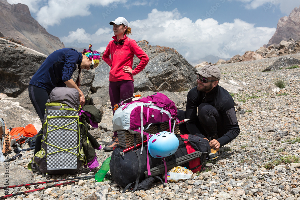 Hikers Packing Backpacks Group of People Man and Women Sitting Staying