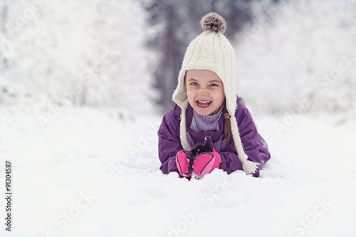 Joyful child lies on the snow