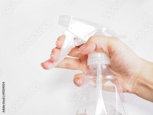 霧吹きを持つ女性の手