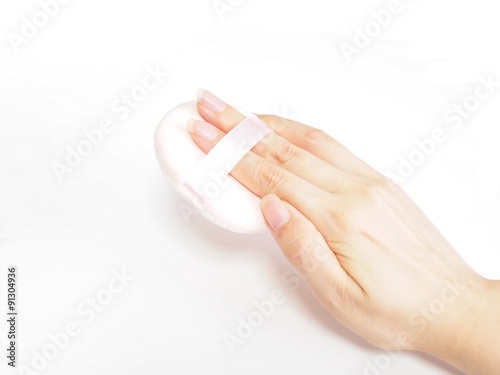 化粧用パフを持つ女性の手