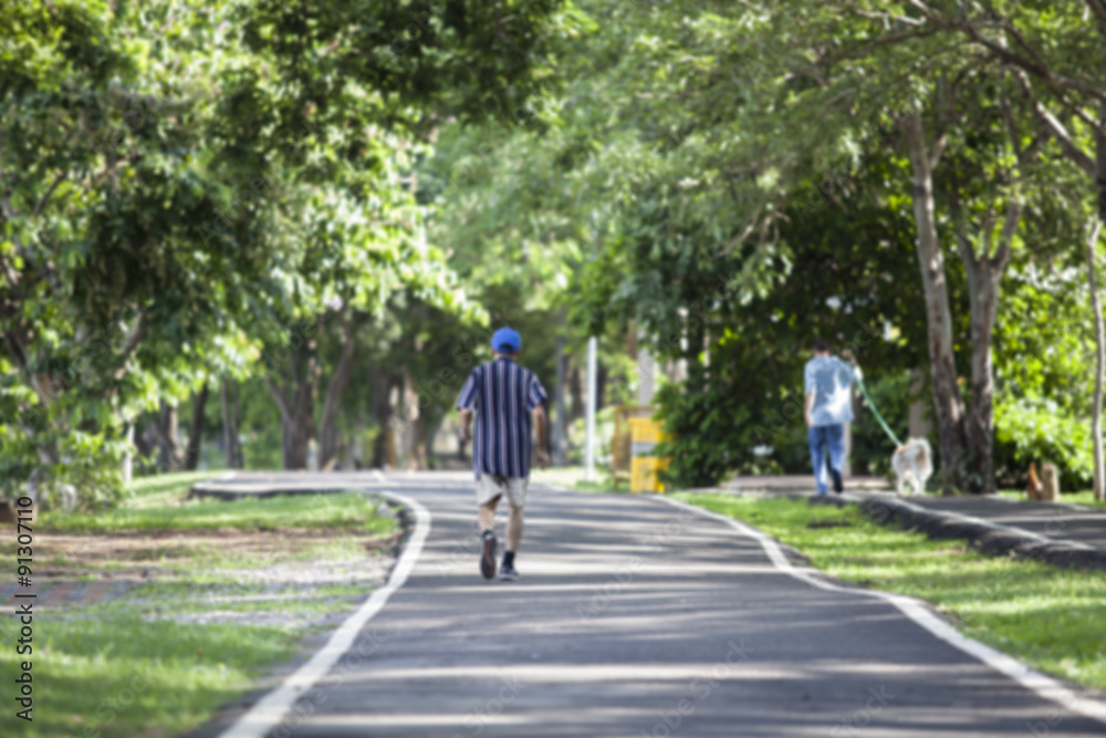 Blur image of man walking in the park