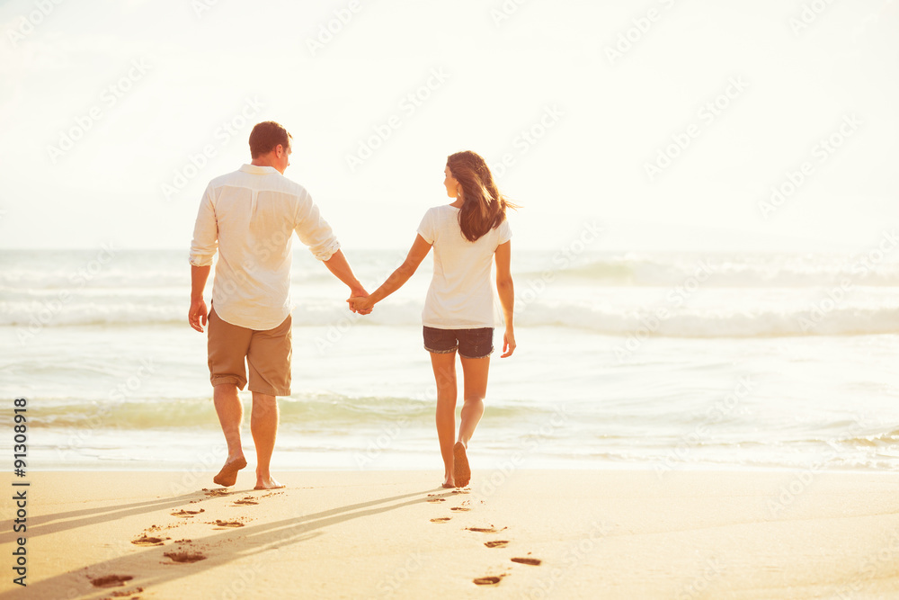 Couple Walking on the Beach at Sunset Couple Walking on the Beach at Sunset