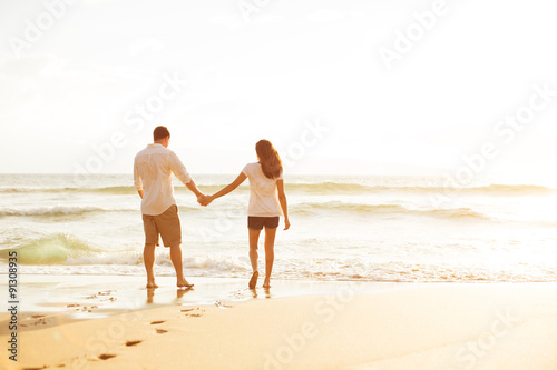 Couple Walking on the Beach at Sunset