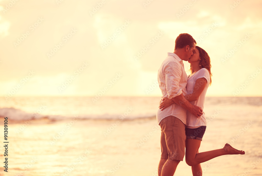 Romantic Couple Kissing on the Beach at Sunset Romantic Couple Kissing on the Beach at Sunset