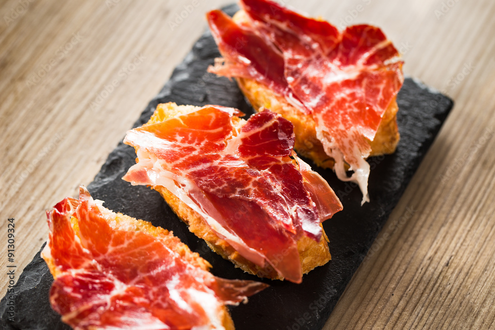 Jamon iberico tapas on a wooden table