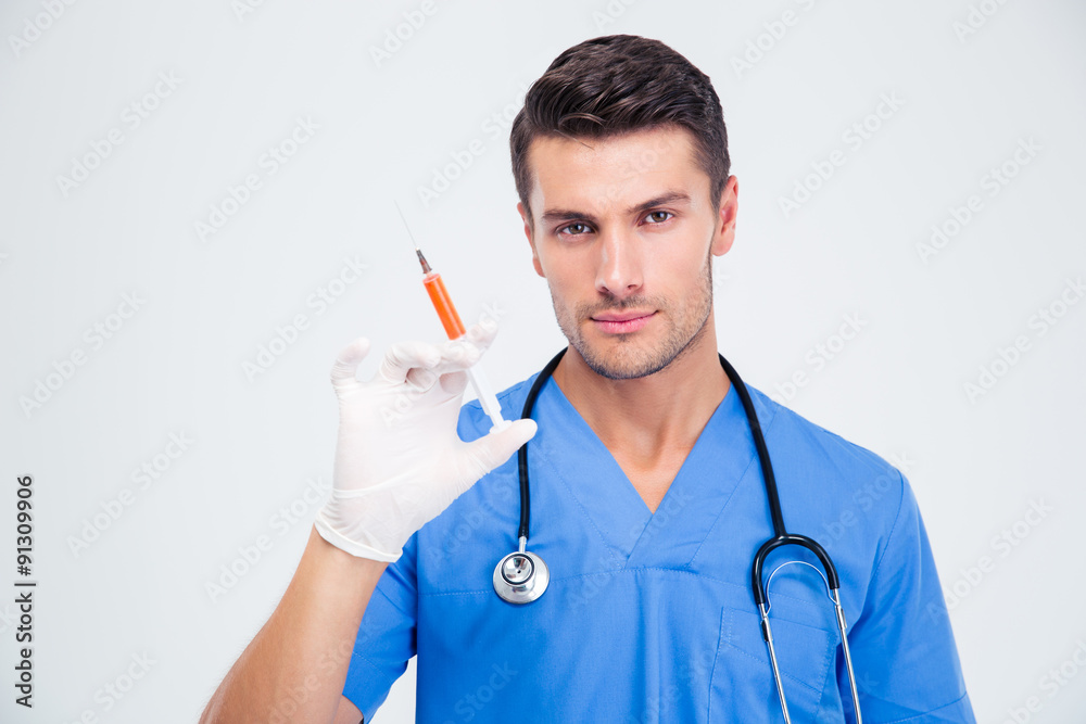 Portrait of a handsome male doctor holding syringe Portrait of a handsome male doctor holding syringe